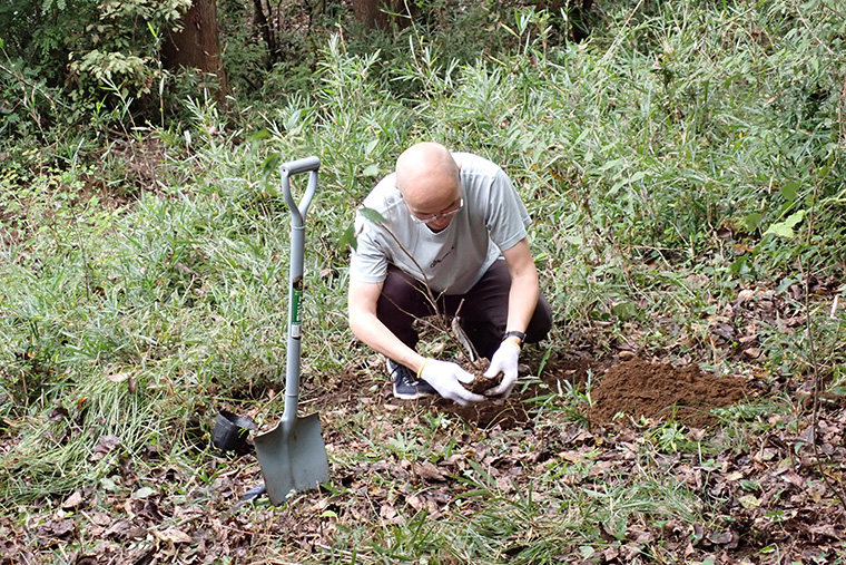 植樹する場所の穴を掘り苗木を植樹したのち、しっかり育つよう想いを込めて回りを踏み固めます