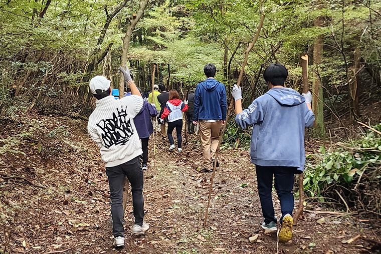 フィールドに除伐（じょばつ）した枝を運ぶ様子