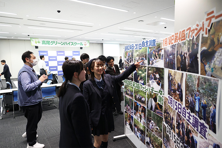 休憩中に1年間の活動写真の展示の前で活動を振り返る様子