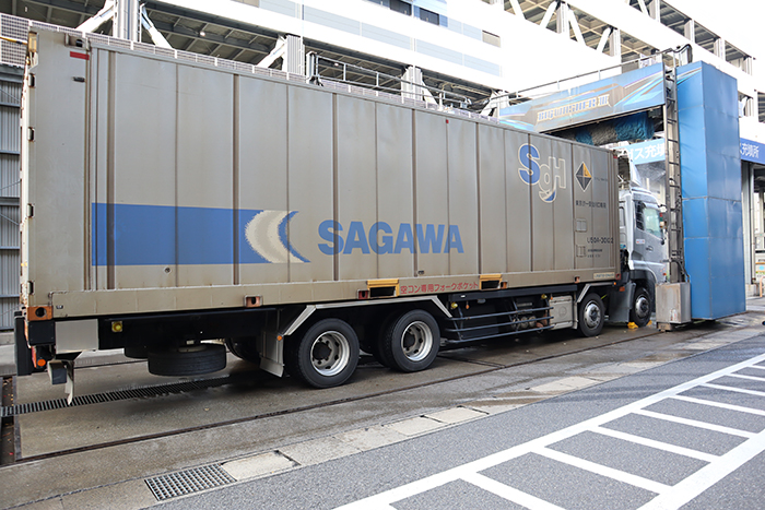 先ほどの大型トラックに続いてもう一台。こちらは東京-大阪間を運行しているスーパーレールカーゴ®(貨物鉄道)のコンテナを積んだ車両。鉄道輸送用のコンテナは鉄粉で茶色っぽくなっているが、こちらも一日の疲れをとるかのように洗車機へ。