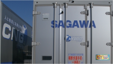 佐川急便の大型車両の後部と側面。後部扉にはHYBRIDのロゴや横断歩道手前での一時停止を促すステッカーがあり、側面にはCNGや人と地球と未来にやさしいといった文字が記されている。