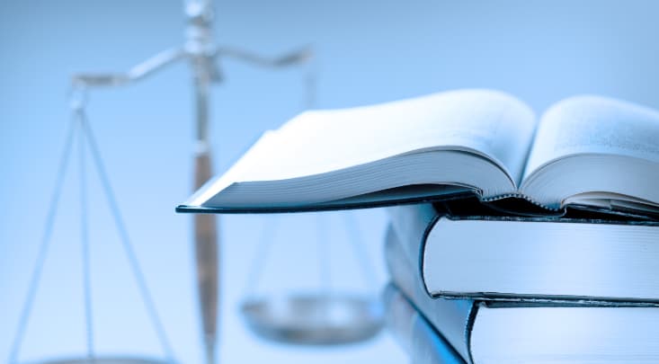 積み重なった厚い本の上に開かれた本