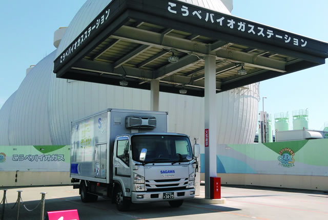 A SAGAWA truck parked at Kobe Bio Gas Station under a shelter.