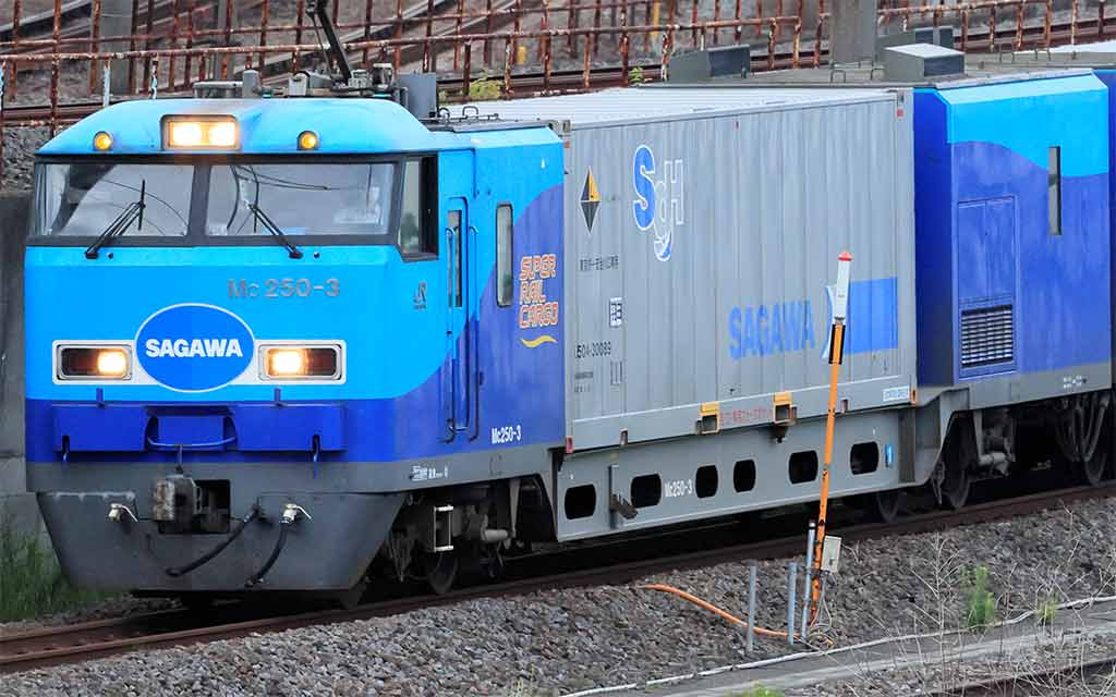 青と水色のSAGAWA貨物列車。先頭車両は Mc 250-3、SUPER RAIL CARGOの文字。連結されたコンテナにはSGHロゴ。